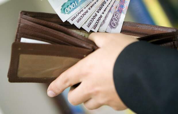 Россия. Курган. Чиновник кладет деньги в кошелек