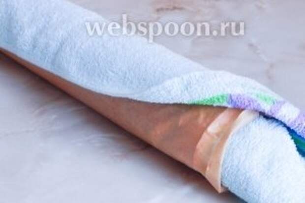 Сразу же, пока бисквит не остыл, прямо с бумагой, сворачиваем его в рулет, подложив под пергамент полотенце. Даём бисквиту так полностью остыть.