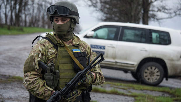 Украинский военный возле машины наблюдателей ОБСЕ возле деревни Широкино, Восточная Украина. Архивное фото Украинский военный возле машины наблюдателей ОБСЕ возле деревни Широкино, Восточная Украина. Архивное фото