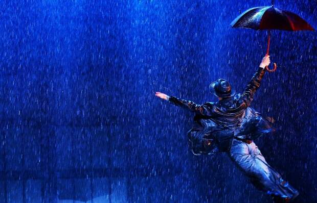 Актер Станислав Чунихин в сцене из мюзикла "Поющие под дождем"