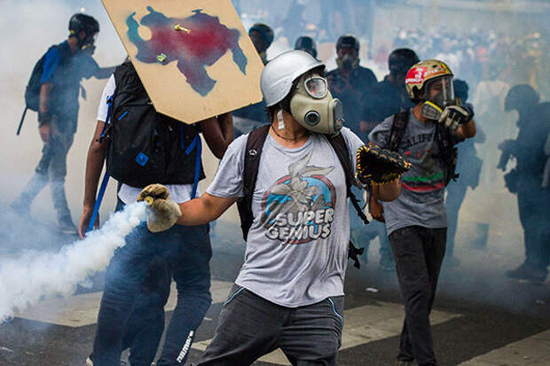 An opposition activist hurls back at riot police a tear gas canister during clashes ensuing a protest against President Nicolas Maduro, in Caracas on May 8, 2017. Venezuela's opposition mobilized Monday in fresh street protests against President Nicolas Maduro's efforts to reform the constitution in a deadly political crisis. Supporters of the opposition Democratic Unity Roundtable (MUD) gathered in eastern Caracas to march to the education ministry under the slogan ''No to the dictatorship. 