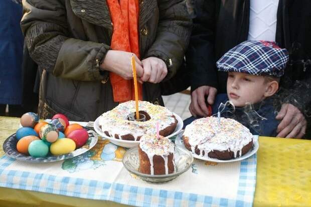 люди освящают пасхальные куличи и яйца
