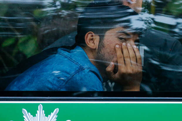 A migrant sits in a police bus after coming from Austria to Germany at the highway A3 in Pocking near Passau, Germany,  Tuesday, Sept. 1, 2015. Hundreds of migrants are arriving every day, after making perilous journeys through Europe. (AP Photo/Matthias Schrader)