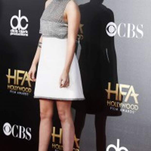 Kristen Stewart flared white skirt rising up gray crop top with pair of Casadei shoes