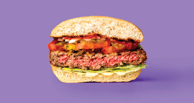 a photo of the Impossible Burger, a meat-free burger on a bun, against a purple background. 