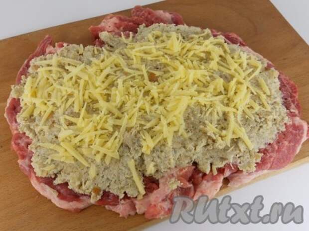 Выложить начинку по всей поверхности отбитого мяса. Сверху посыпать тертым сыром.