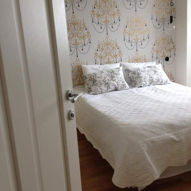 Спальня в скандинавском стиле, кровать по белым покрывалом