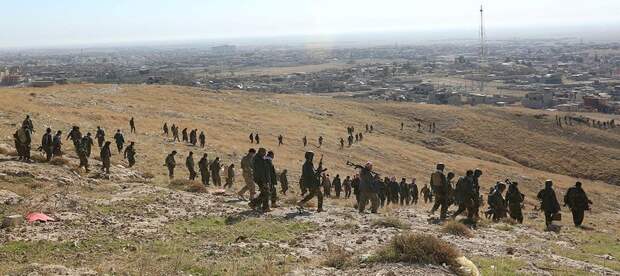 Members of the Kurdish peshmerga forces gather in the town of Sinjar