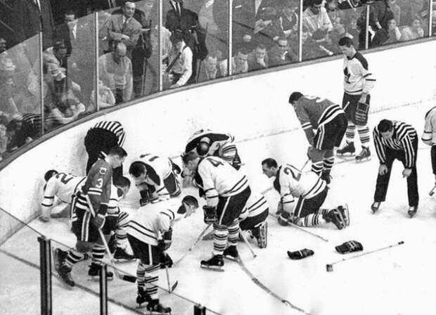 Ice Hockey players and referees searching for a contact lens in 1962