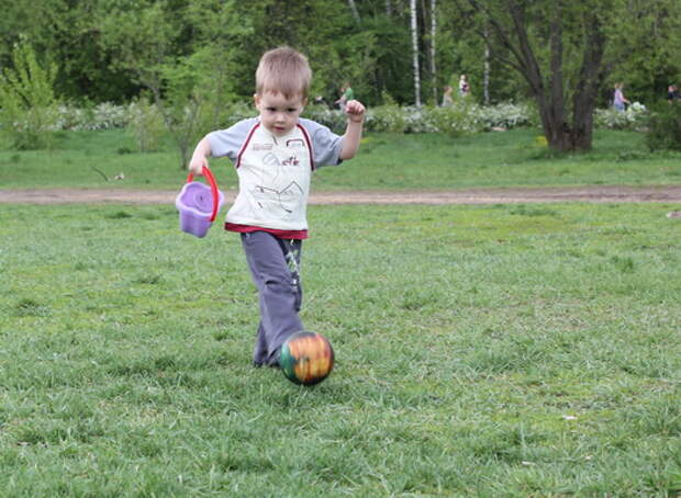 Мальчик играет с мячом на прогулке с папой. Будущий футболист
