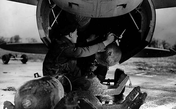 A photograph of a Mosquito FB VI being loaded with bombs by the armourer