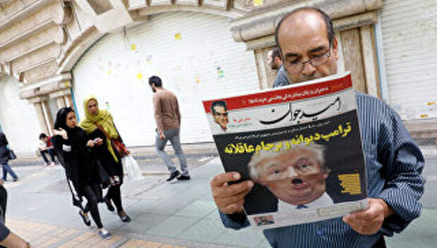 Мужчина читает ежедневную газету на улице Тегерана после заявления президента США Дональда Трампа о политике США относительно Ирана