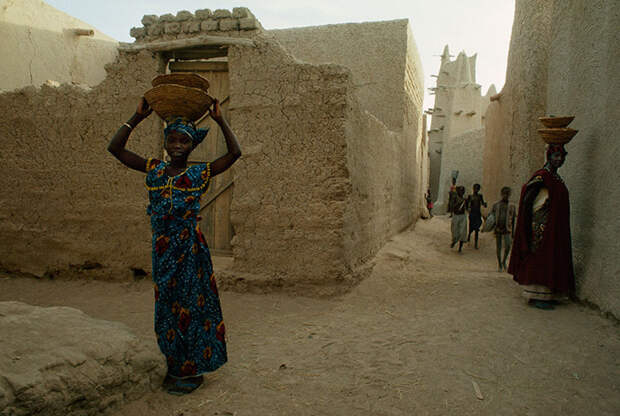 42. Женщины несут корзины на головах, пока дети играют. Котака, Мали, 1991 national geographic, история, природа, фотография