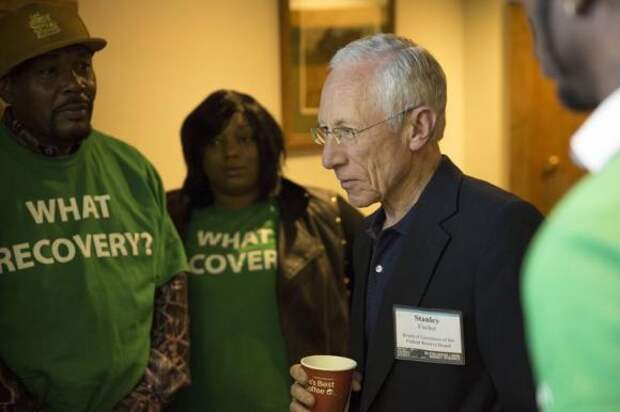 Stanley Fischer, vice chairman of the Federal Reserve System, speaks with demonstrators from the Center for Popular Democracy at the Jackson Hole Economic Policy Symposium in Jackson Hole, Wyoming August 22, 2014. REUTERS/David Stubbs