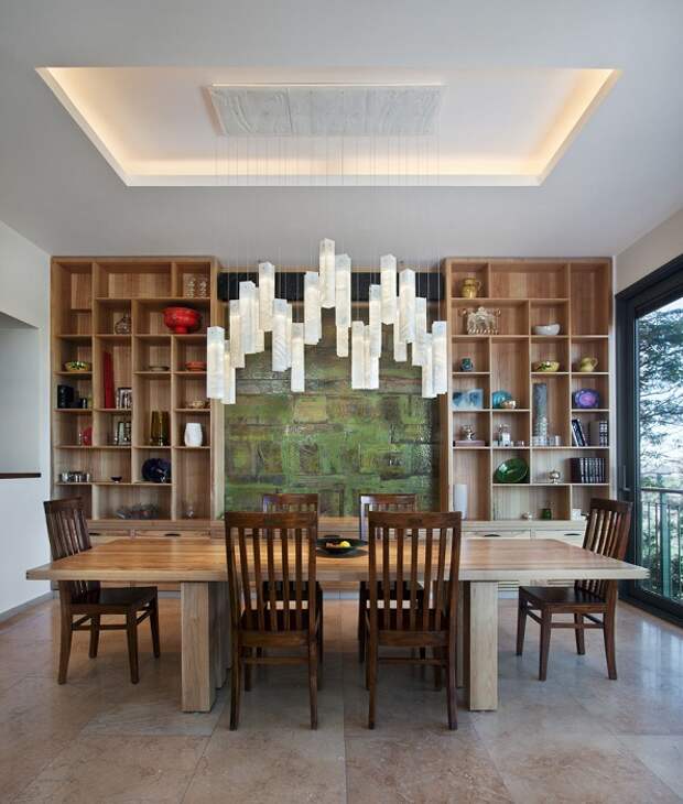 Множество деревянных элементов интерьера дополнены прекрасной люстрой над столом.