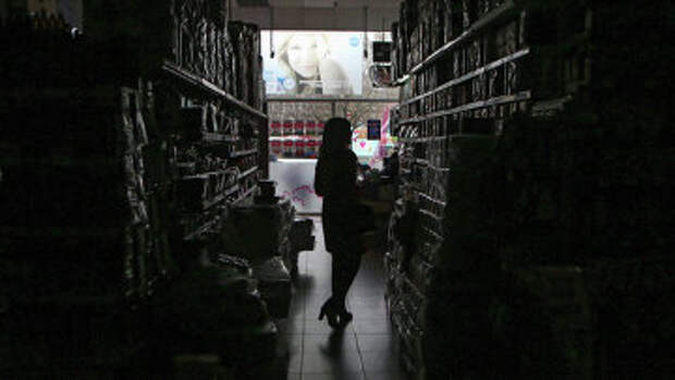 Покупательница в обесточенном торговом зале одного из магазинов в Симферополе. Архивное фото