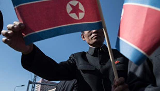 Мужчина с флагом КНДР в Пхеньяне