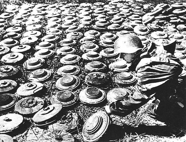 Советский солдат-сапер 1-ой штурмовой инженерно-сапёрной бригады работает с обезвреженными немецкими противотанковыми минами. На снимке немецкие противотанковые мины T.Mi. 42, T.Mi. 35 Stahl и T.Mi.Pilz 43. Предположительное время съемки, после марта Великая Отечественная война, СССР, Солдаты моей страны