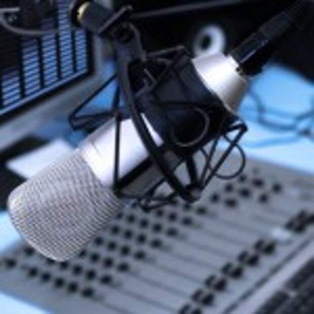 A mic in front of the control panel in broadcasting studio