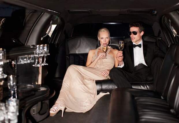 Two young millionaires in a limo drinking champagne