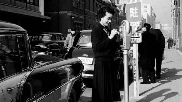 Первый паркомат в Токио. Девушка-посыльный оплачивает парковку. 19 января 1959