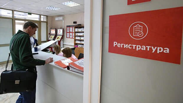 Посетитель у регистрационного стола в поликлинике Посетитель у регистрационного стола в поликлинике