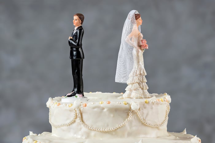 Bride and groom cake toppers facing in opposite directions.