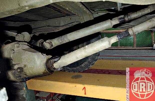 От раздаточной коробки к задней тележке идут два карданных вала.