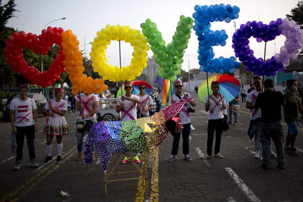 Revelers hold balloons, representing the colors of a rainbow, to form the word, "Love" during the annual gay pride parade in Lima, Peru, Saturday, June 27, 2015. (AP Photo/Rodrigo Abd) ORG XMIT: ABD107