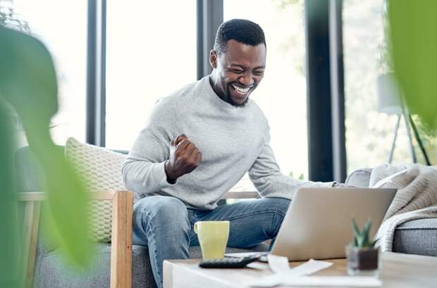 Person celebrating success while looking at computer.