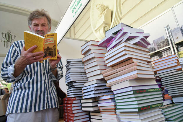 Посетитель читает книгу на книжной ярмарке во Львове Посетитель читает книгу на книжной ярмарке во Львове - РИА Новости, 1920, 25.09.2020