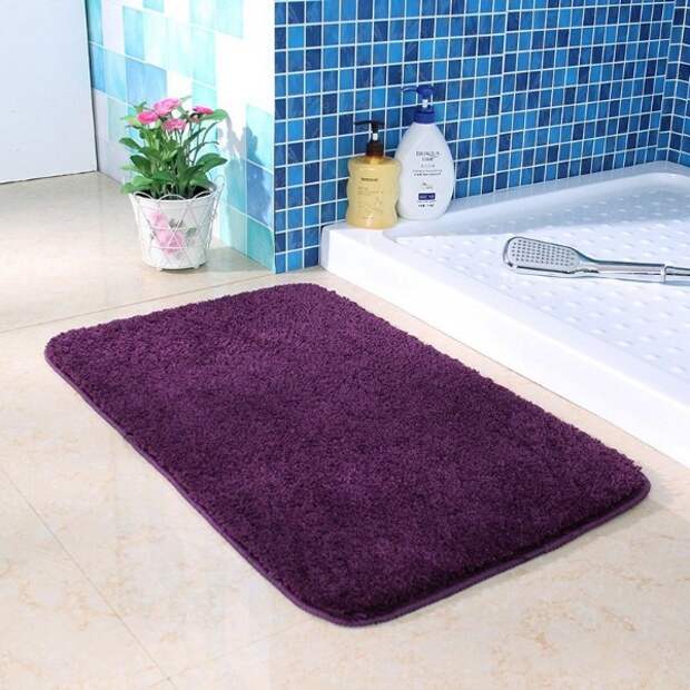 коврик фиолетового цвета на полу в ванной комнате
