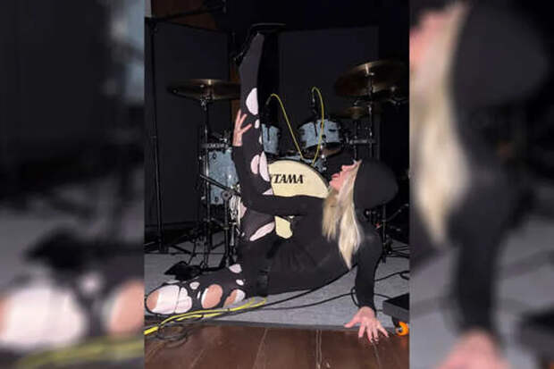 Глюкоза показала растяжку в рваных колготках на фоне барабанов