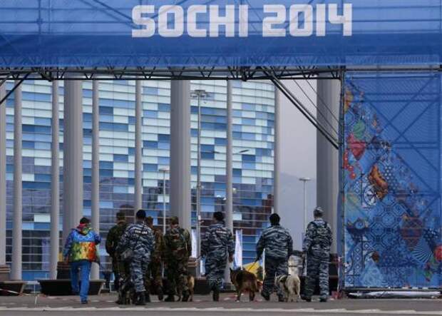 Police officers walk with sniffer dogs trained to search for explosives, as they patrol at the Olympic Park in the Adler district of Sochi, January 28, 2014. REUTERS/Alexander Demianchuk