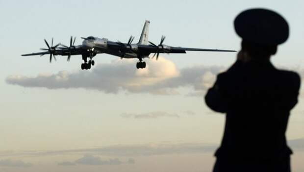 A Russian officer takes a picture of a TU-95 bomber, or Bear, at a military airbase in Engels