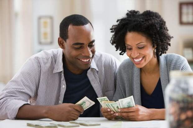 Smiling couple counting money together.