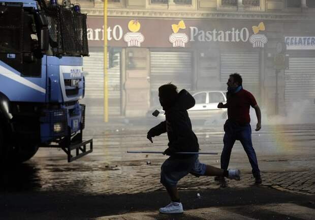 Protestors attack a police vehicle durin