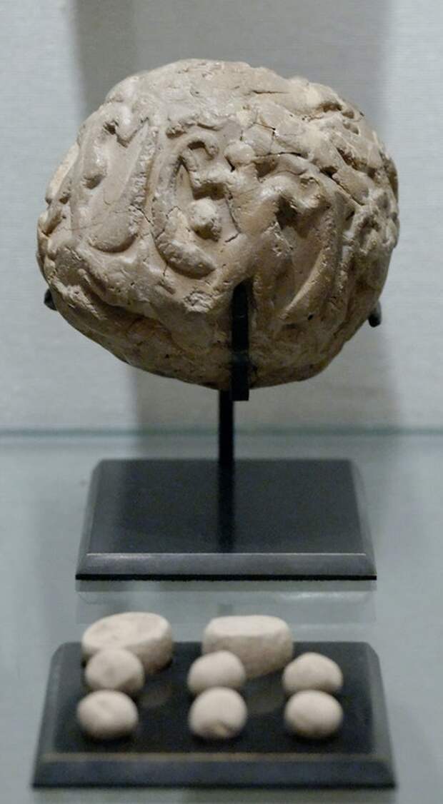 A bulla (or clay envelope) and its contents on display at the Louvre. Uruk period