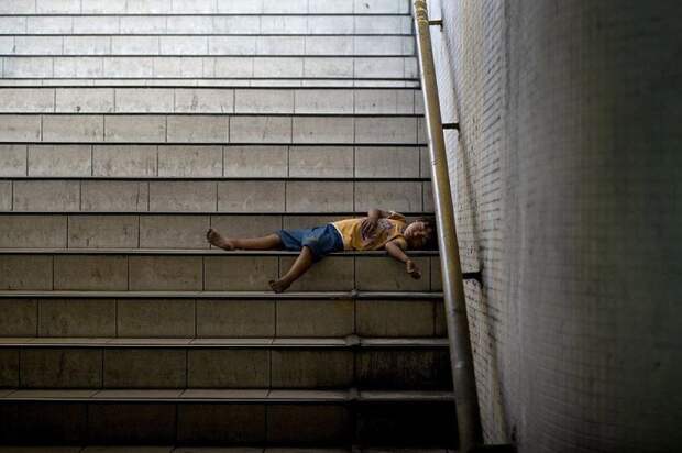 Ребенок спит на ступеньках подземного перехода.