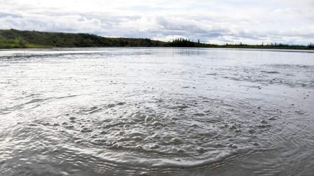Метан, поднимающийся из глубины одного из озер северной Аляски