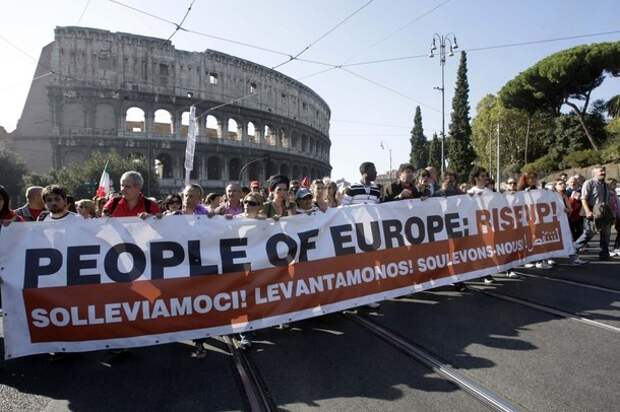Protesters of the 'Indignant' group walk past the Colosseum during a demonstration against banking and finance in Rome