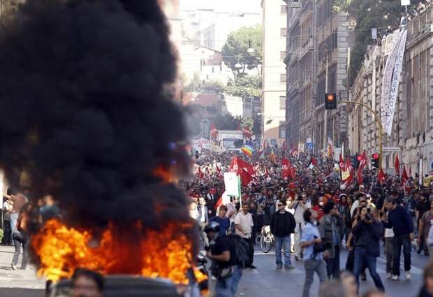 A car burns during a demonstration of the 'Indignant' group against banking and finance in Rome