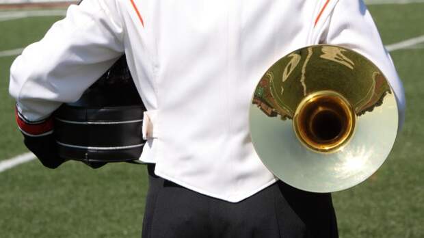 A band member stands on the field before a football game.