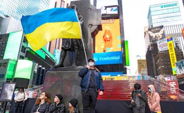 На фото: мужчина держит украинский флаг на Таймс-сквер, Нью-Йорк, США