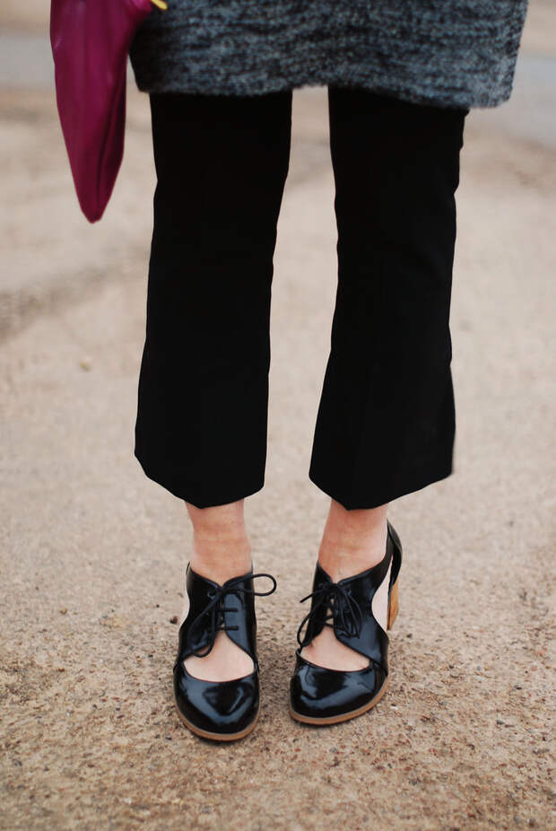 Grey sweater dress layered over black trousers, cut out shoes