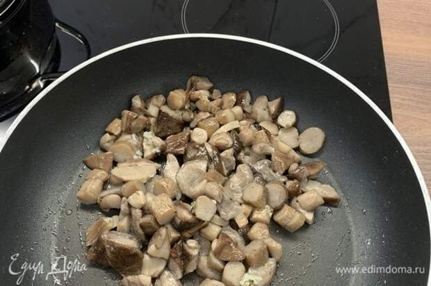 Добавить грибы и обжарить на огне чуть выше среднего до появления румяной корочки.