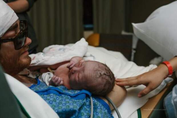 Мужчина, который проходит лечение рака головного мозга, держит на руках новорожденного сына