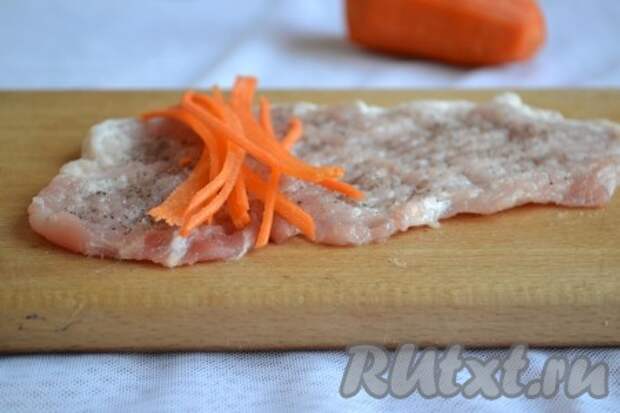 Очищенную морковь нарезать (или натереть) длинными полосками. Полоски моркови выложить на отбитые куски свинины и свернуть рулетиком. 
