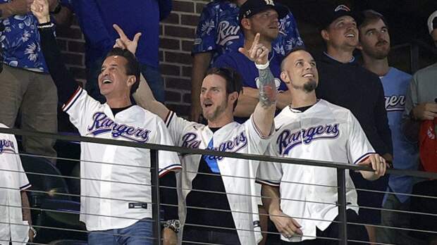 Creed band members watch on as the Rangers play the Astros in the ALCS.