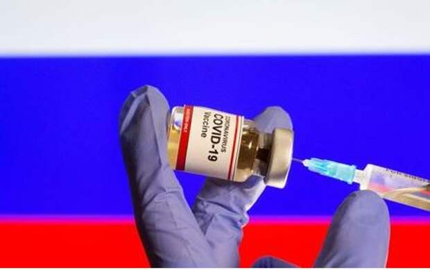 A woman holds a small bottle labeled with a 